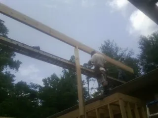 Carpenter setting a ridge beam over a new addition frame — Ice Dam Removal by Roofing Brothers in West Jordan