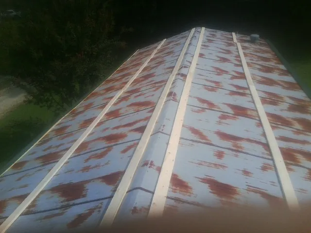 Rusted metal roof panels with new wood purlins before replacement — Storm Damage Roof Repair in West Jordan by Roofing Brothers