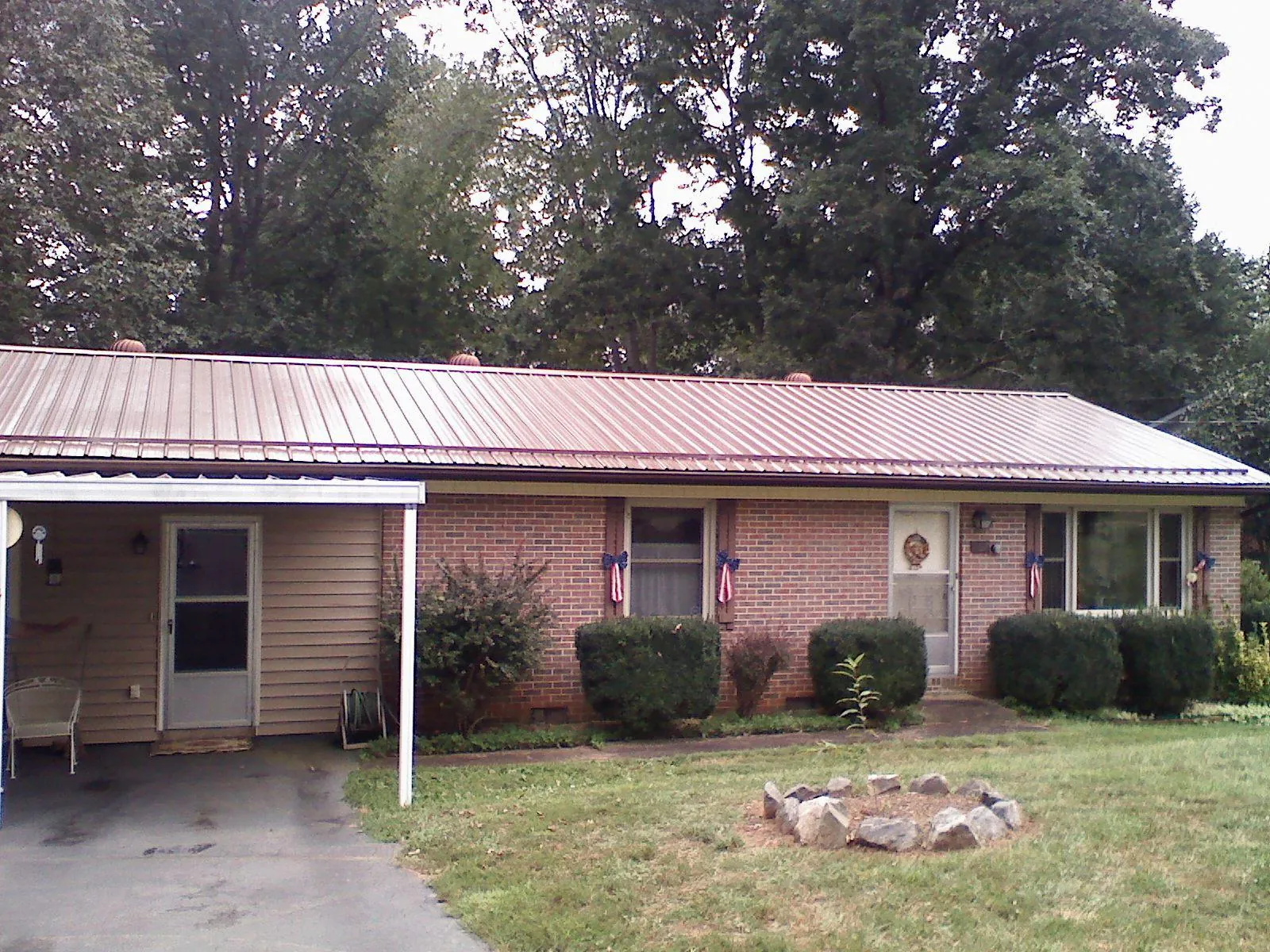 Bronze metal roof and carport on a brick ranch home — Roof Repair work by our crew in West Jordan