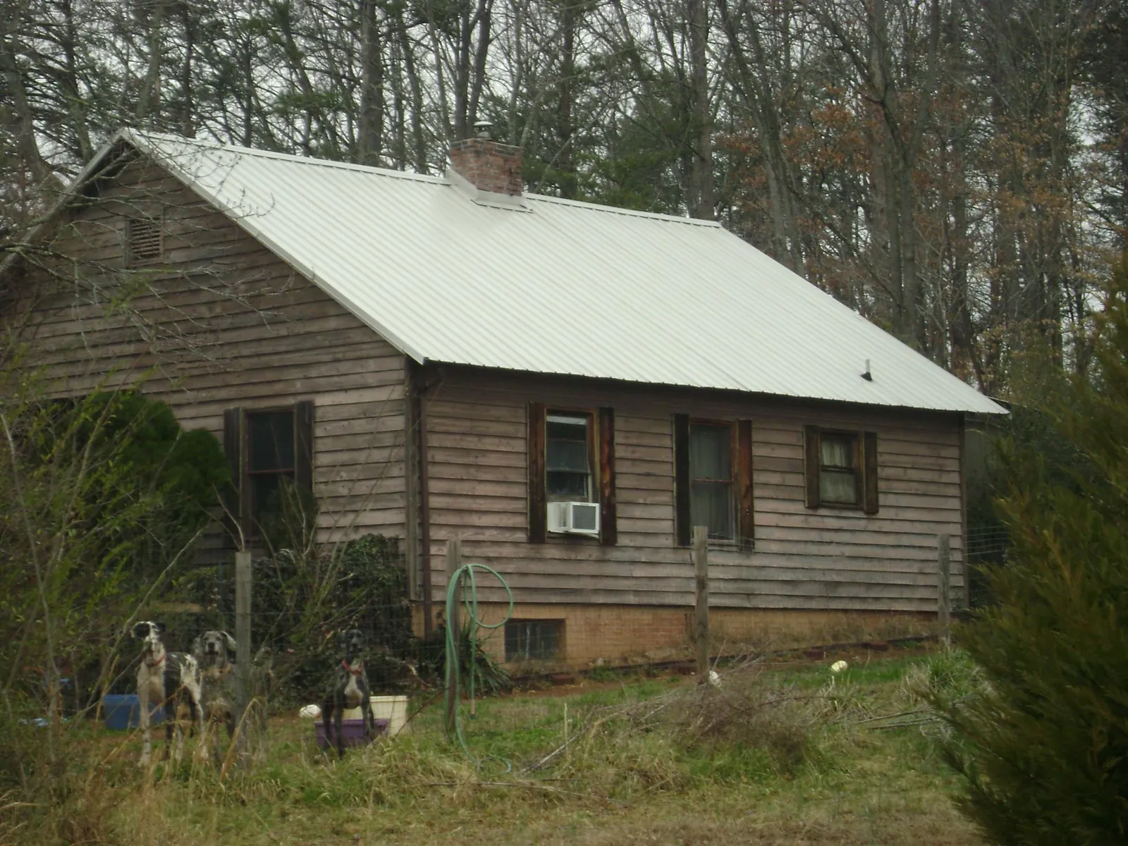 White metal roof on an old wood sided farmhouse, from a Asphalt Shingle Roof Repair job in West Jordan